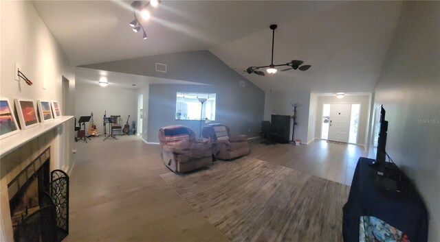 living room featuring ceiling fan, high vaulted ceiling, and light hardwood / wood-style floors