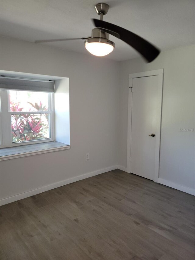 empty room featuring ceiling fan and dark hardwood / wood-style flooring