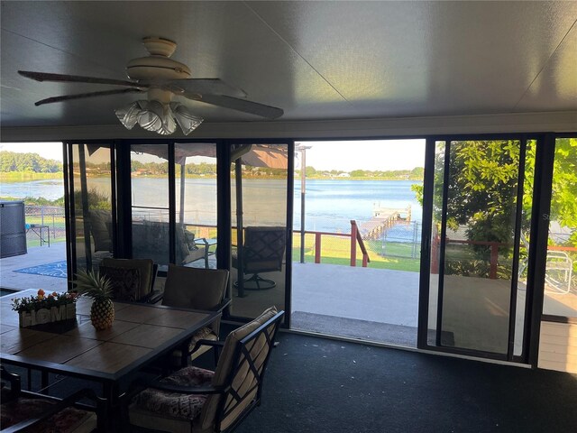 sunroom / solarium with a water view and ceiling fan