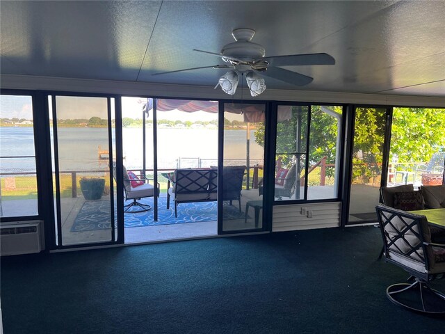 unfurnished sunroom with a water view, ceiling fan, and a wall unit AC