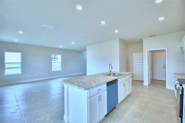 kitchen with appliances with stainless steel finishes, sink, light tile floors, white cabinets, and a center island with sink