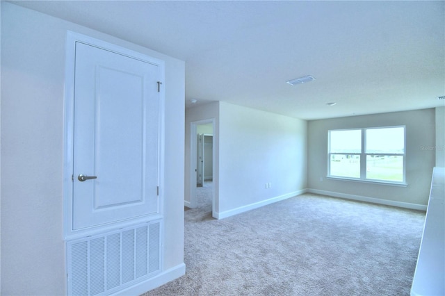 unfurnished room featuring light carpet