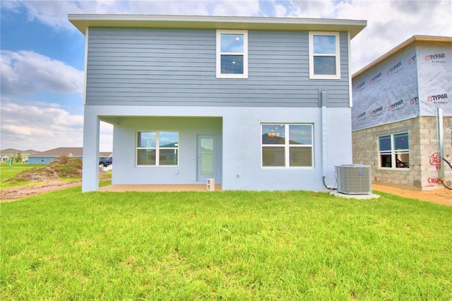 back of property with central air condition unit and a lawn