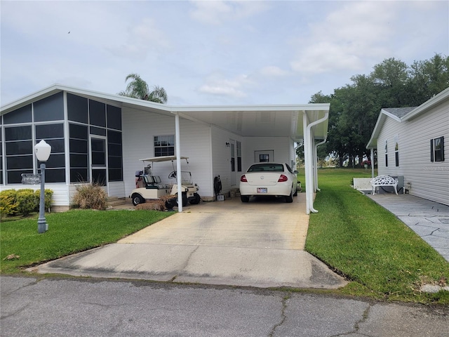 manufactured / mobile home featuring a front lawn and a carport