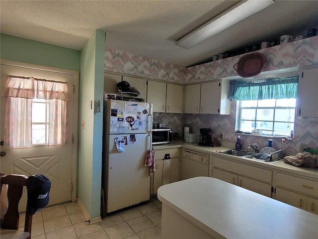 kitchen with tasteful backsplash, white appliances, a textured ceiling, and light tile floors