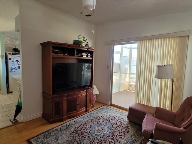 tiled living room featuring a textured ceiling