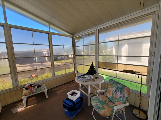 sunroom with wooden ceiling, vaulted ceiling, and a healthy amount of sunlight