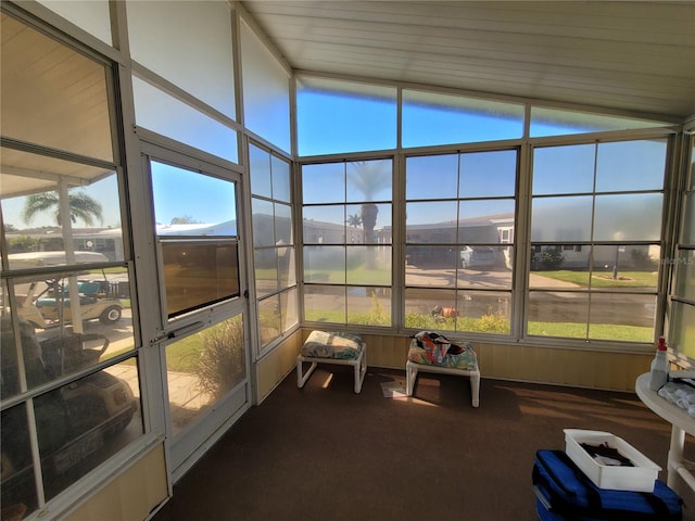 unfurnished sunroom featuring vaulted ceiling and a healthy amount of sunlight