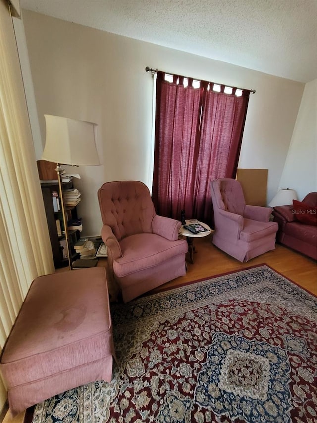 living room with a textured ceiling and light wood-type flooring