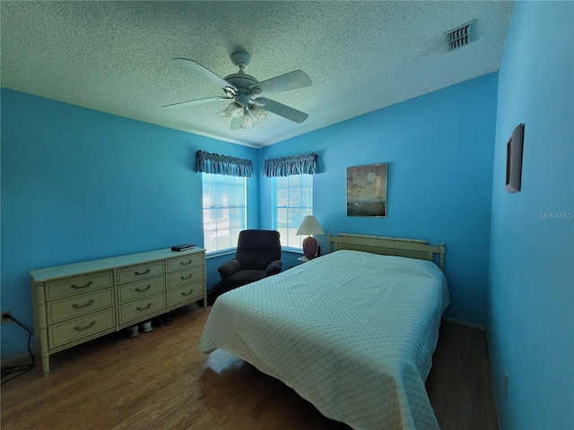 bedroom featuring ceiling fan, a textured ceiling, and hardwood / wood-style floors