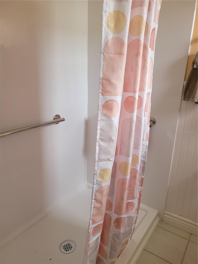 bathroom with tile floors and a shower with shower curtain