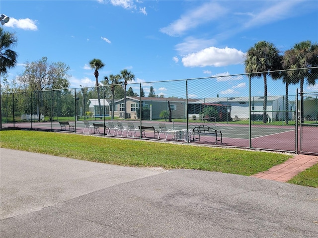 view of tennis court with a yard