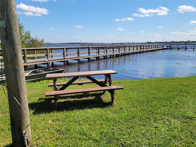 dock area featuring a water view and a yard