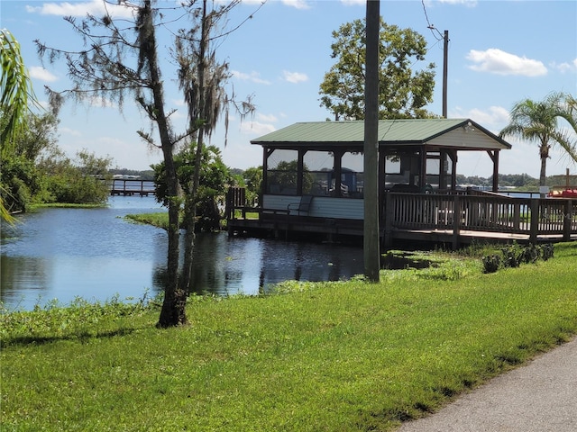 view of dock with a gazebo, a water view, and a yard