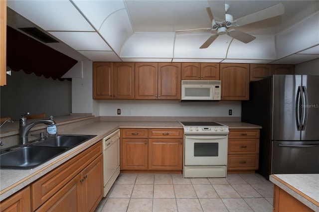 kitchen featuring light tile flooring, white appliances, ceiling fan, and sink