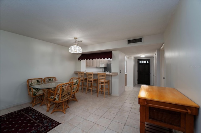 tiled dining room with an inviting chandelier