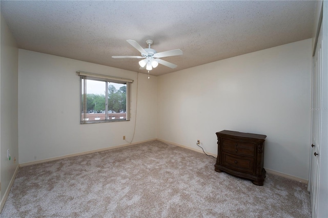 carpeted spare room with ceiling fan and a textured ceiling