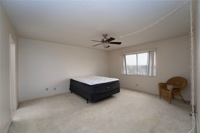 unfurnished bedroom with light colored carpet, a textured ceiling, and ceiling fan