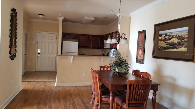 dining space with crown molding and light tile floors