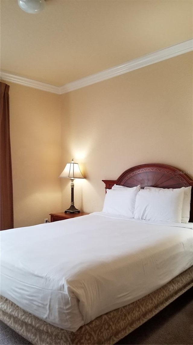 bedroom featuring carpet flooring and crown molding