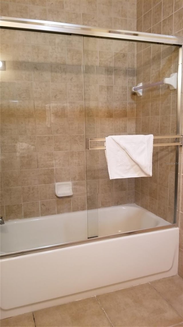 bathroom with enclosed tub / shower combo and tile flooring