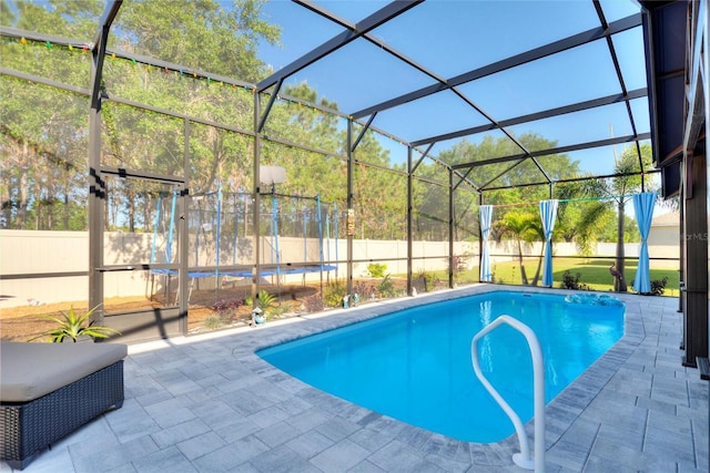 view of swimming pool with a patio area and a lanai