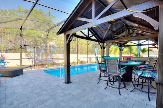 view of swimming pool with glass enclosure and a patio