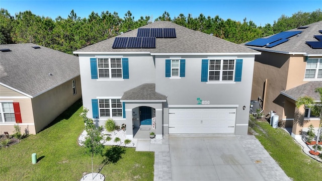 view of front of property with a front lawn, a garage, and solar panels