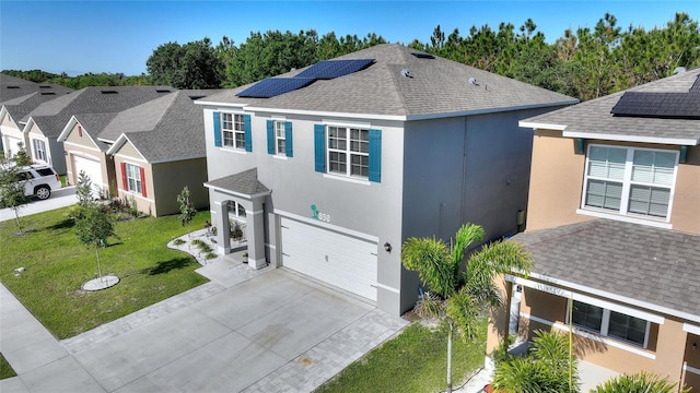 view of front of house with solar panels, a garage, and a front yard