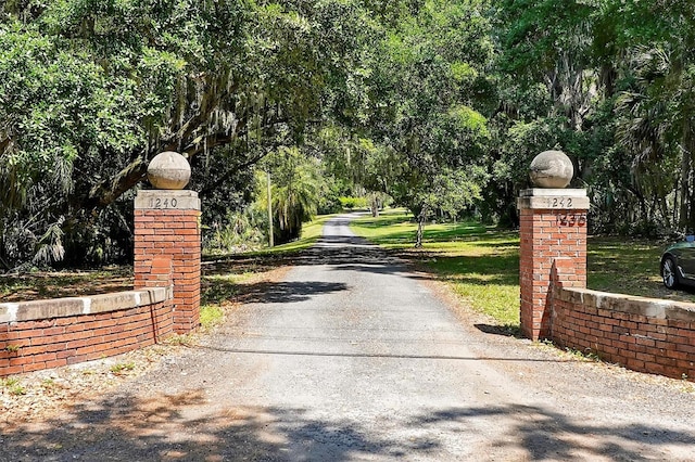 view of gate with a lawn