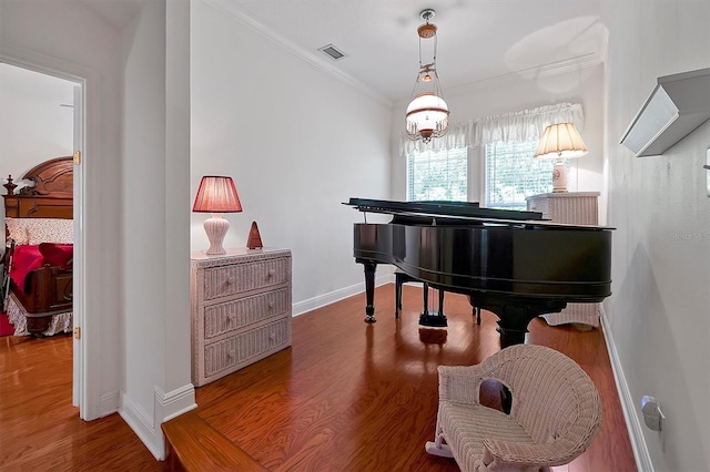 miscellaneous room with ornamental molding, an inviting chandelier, and wood-type flooring