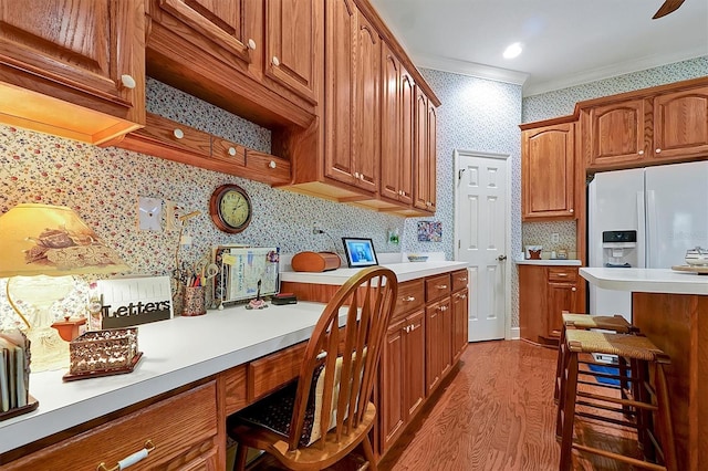 kitchen featuring a kitchen breakfast bar, dark hardwood / wood-style flooring, white fridge with ice dispenser, and crown molding