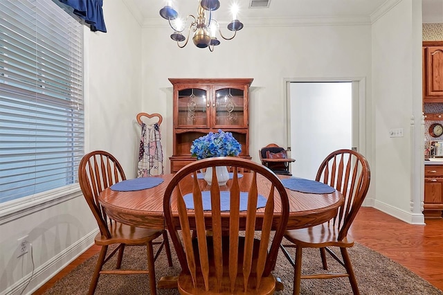 dining area featuring a chandelier, hardwood / wood-style flooring, and crown molding