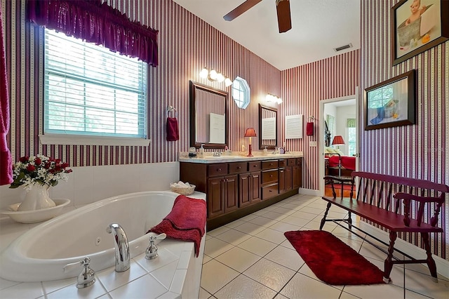 bathroom featuring dual sinks, ceiling fan, tile flooring, vanity with extensive cabinet space, and a bath