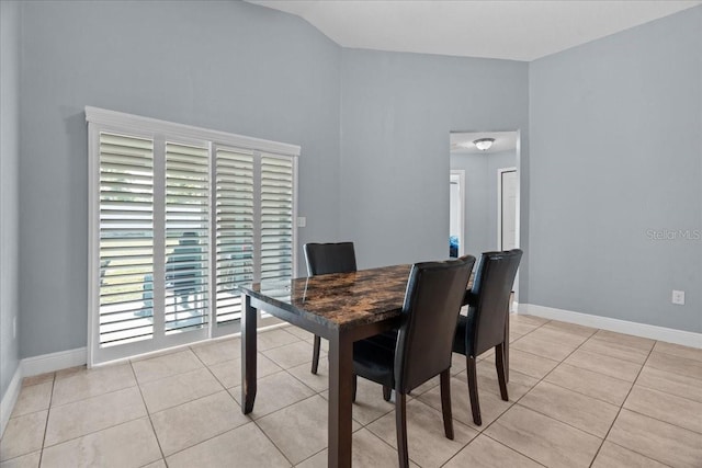 dining space with high vaulted ceiling and light tile floors