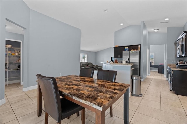 tiled dining space with vaulted ceiling