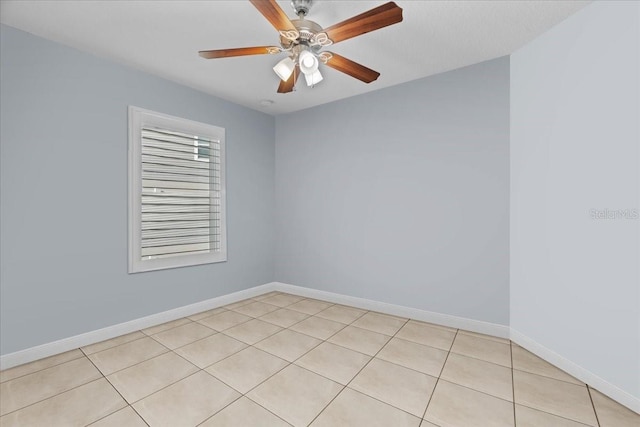 tiled spare room with ceiling fan