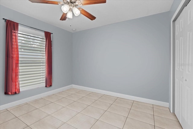 spare room featuring ceiling fan and light tile flooring