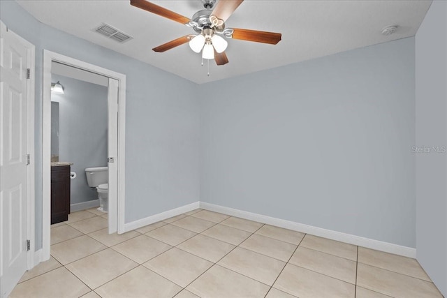 tiled spare room featuring ceiling fan