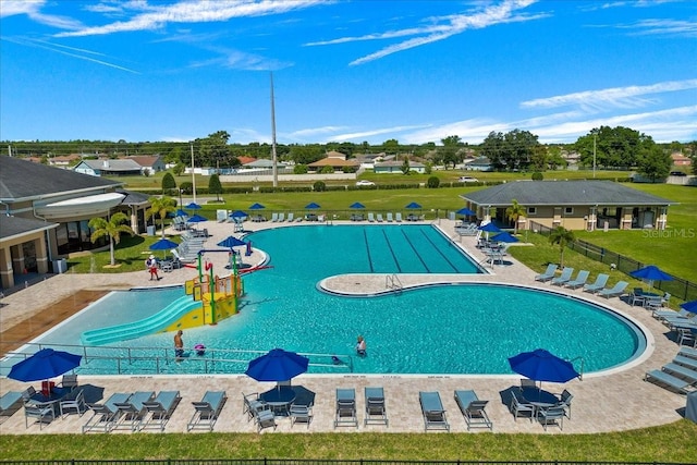 view of pool with a patio and a yard