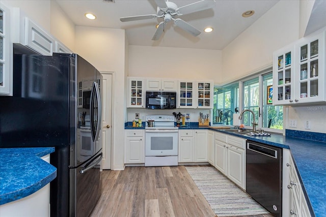 kitchen featuring white cabinetry, sink, ceiling fan, black appliances, and light wood-type flooring