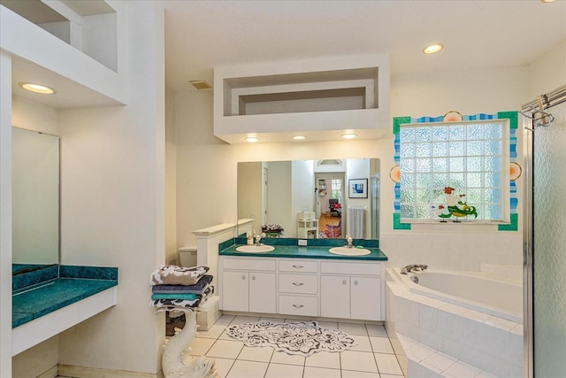 bathroom featuring vanity, tile patterned flooring, and tiled tub