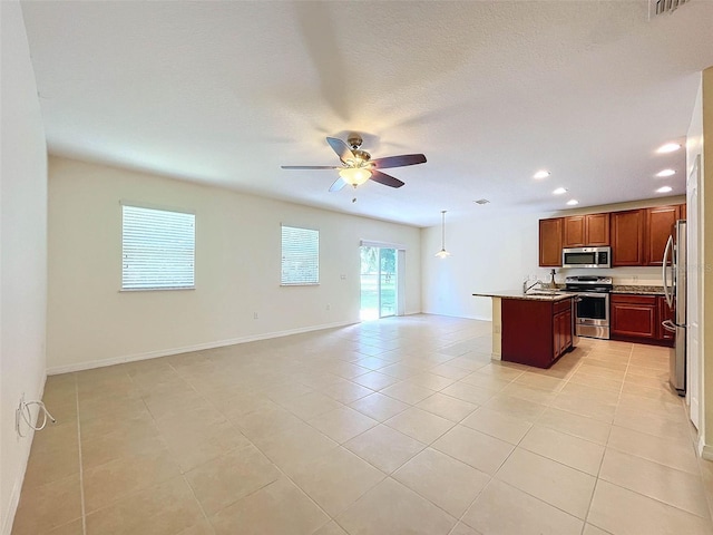 kitchen with hanging light fixtures, light tile flooring, appliances with stainless steel finishes, a center island with sink, and ceiling fan