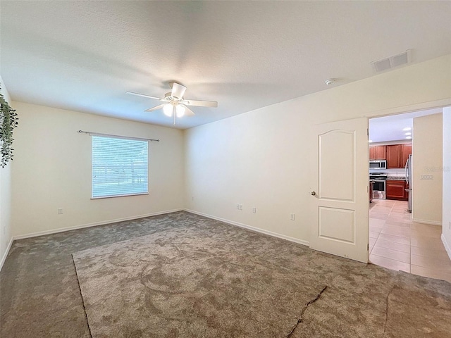 empty room featuring ceiling fan and carpet