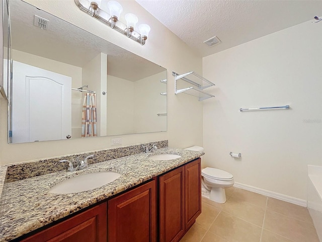 bathroom featuring toilet, tile floors, a textured ceiling, and double sink vanity