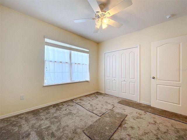 unfurnished bedroom with a closet, ceiling fan, carpet, and multiple windows