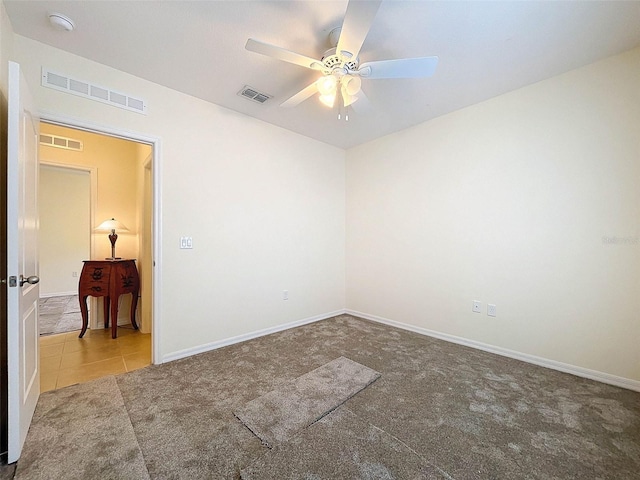 carpeted spare room with ceiling fan