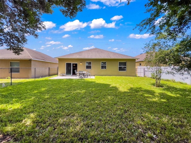 rear view of house with a patio and a yard