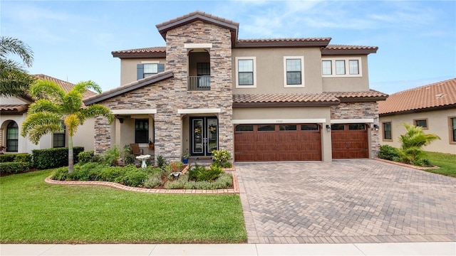 mediterranean / spanish house featuring a front lawn and a garage