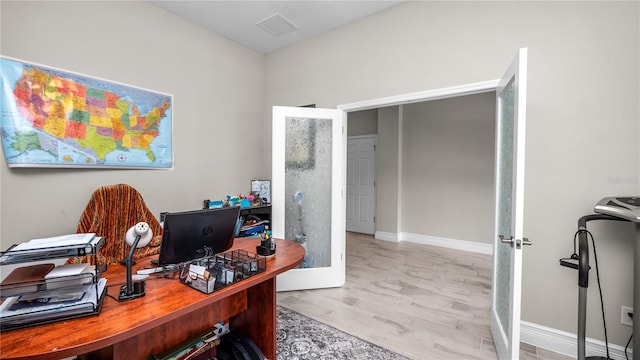 office space featuring french doors and light hardwood / wood-style flooring